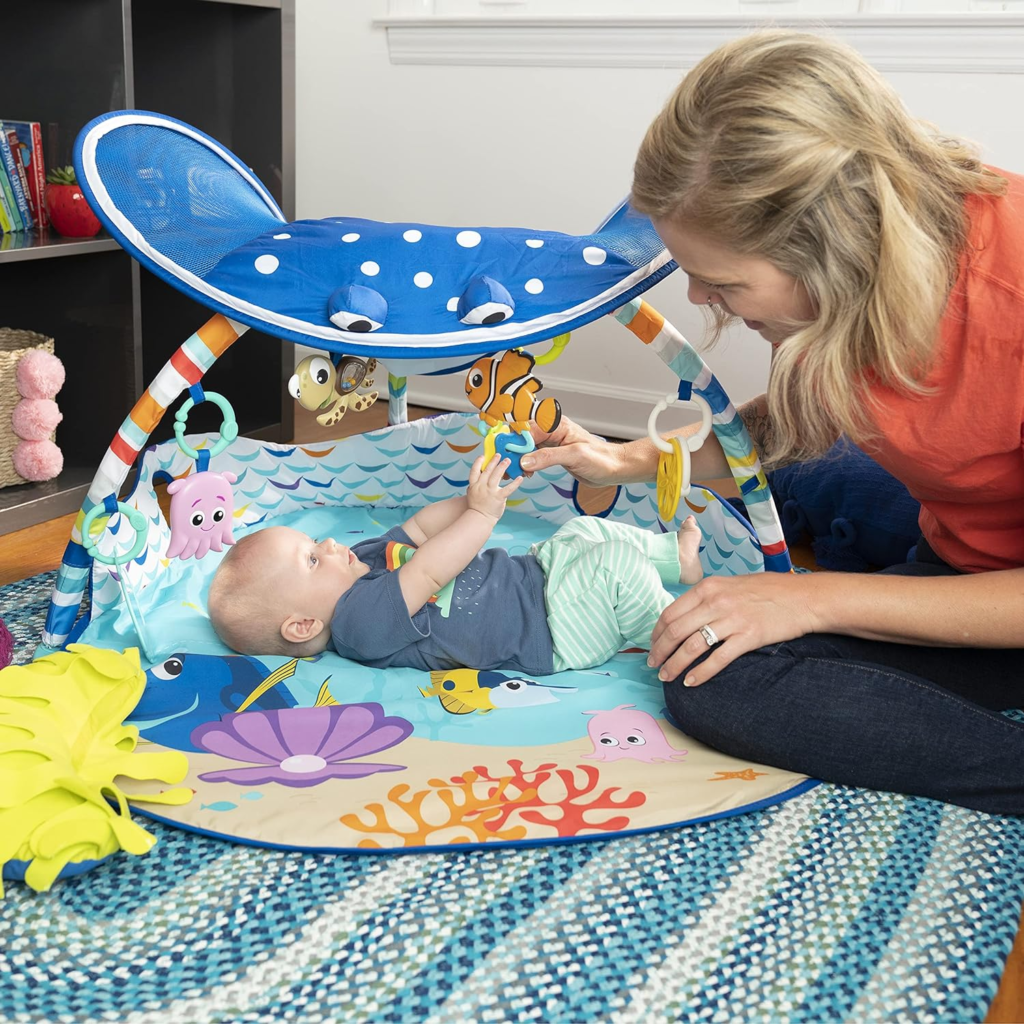 Baby Play Gym: image of a parent playing with their baby on a play gym, emphasizing interaction and bonding. Bright Start