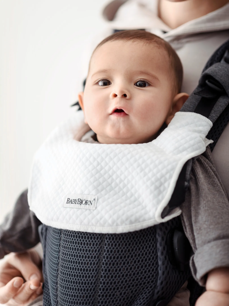 Baby Carrier: A baby carrier with teething pads attached to the straps.