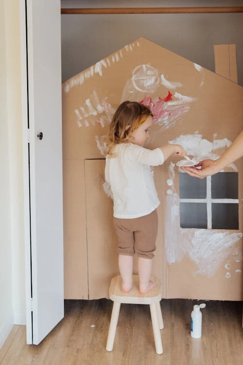 Image of a family enjoying a messy, fun activity like painting: This can depict the joy of imperfection in parenting.