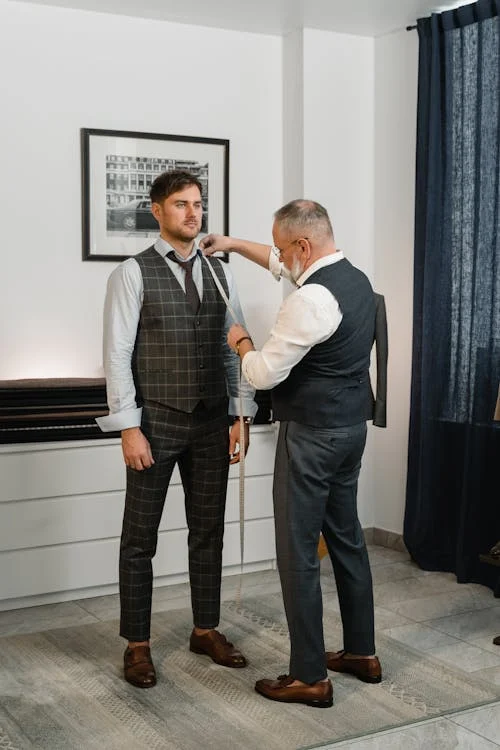 A person getting measured by a tailor.