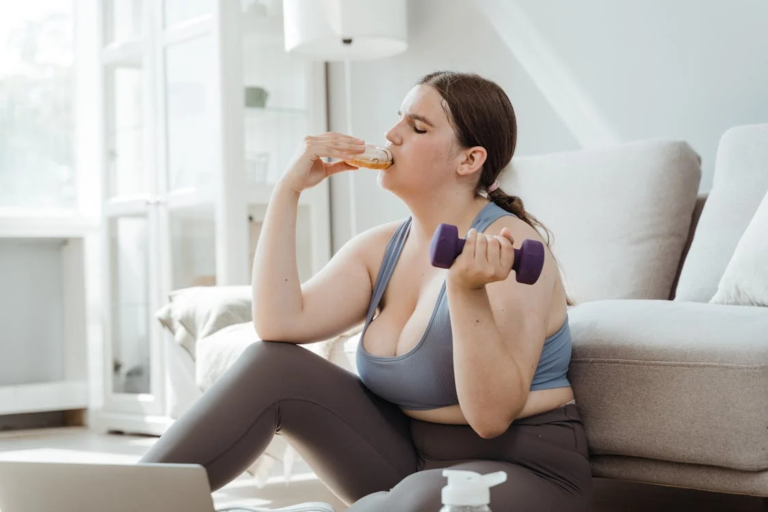 Overeating: An image of a woman eating a donut while holding a dumb bell. She is in her work out clothes, but looks overweight.