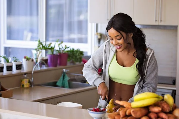 An image of a woman preparing a healthy meal in her kitchen. 